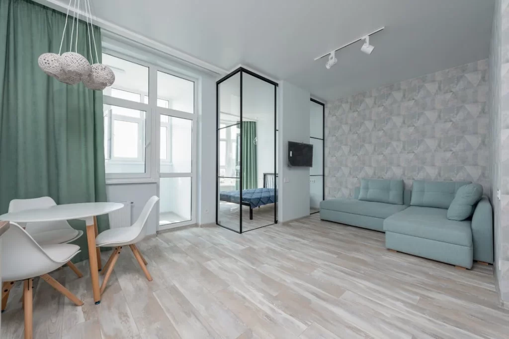How to choose curtains for your living room: Green curtains in a pale living room.
